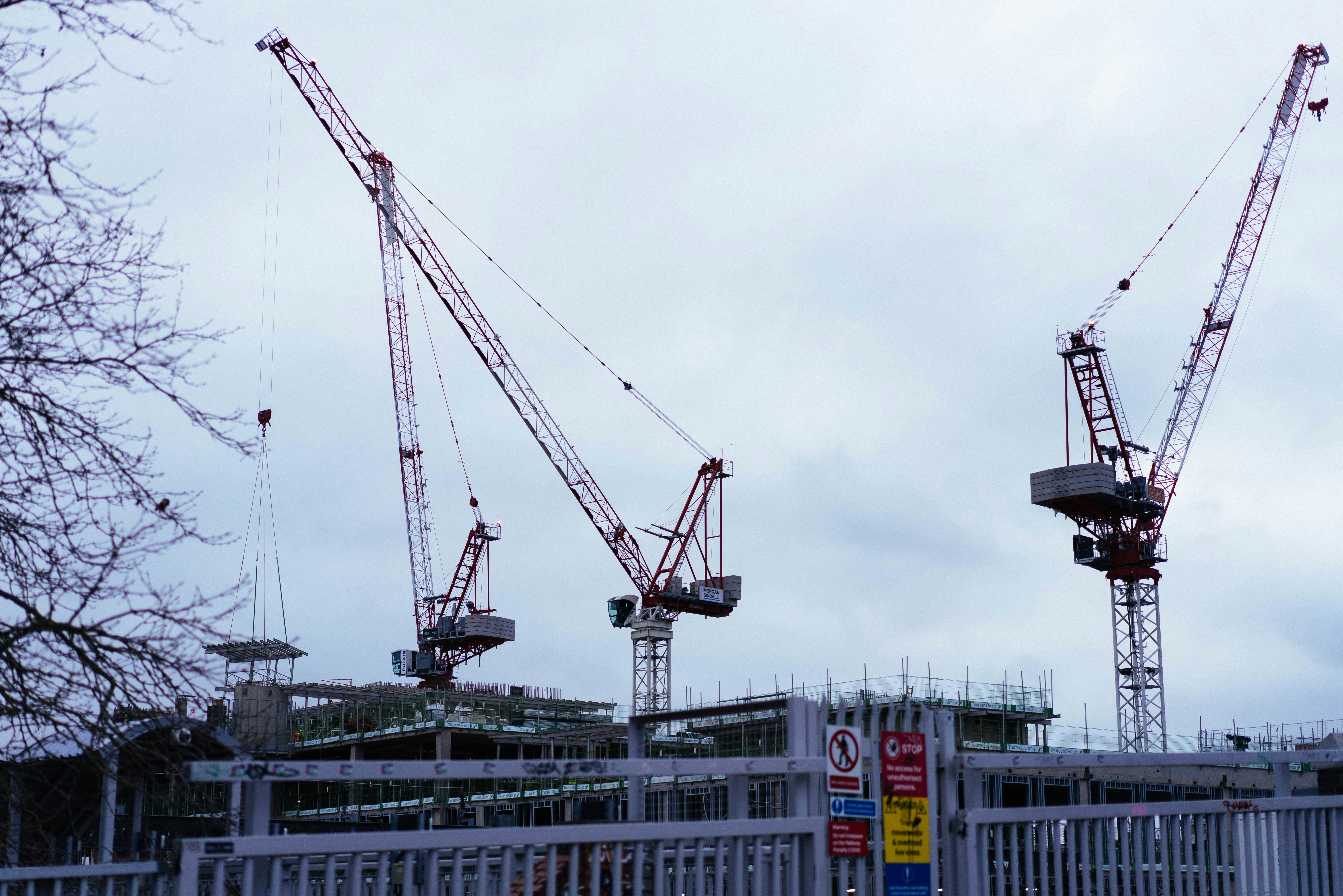 Tower cranes over a structural steel frame on a construction site